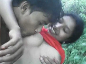 A girl's boyfriend reveals her breasts and orally pleasures them in a wooded area