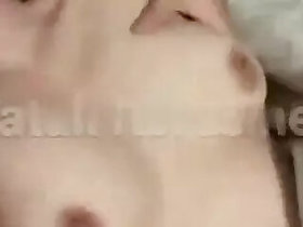 A guy presses a naked girl against his tits